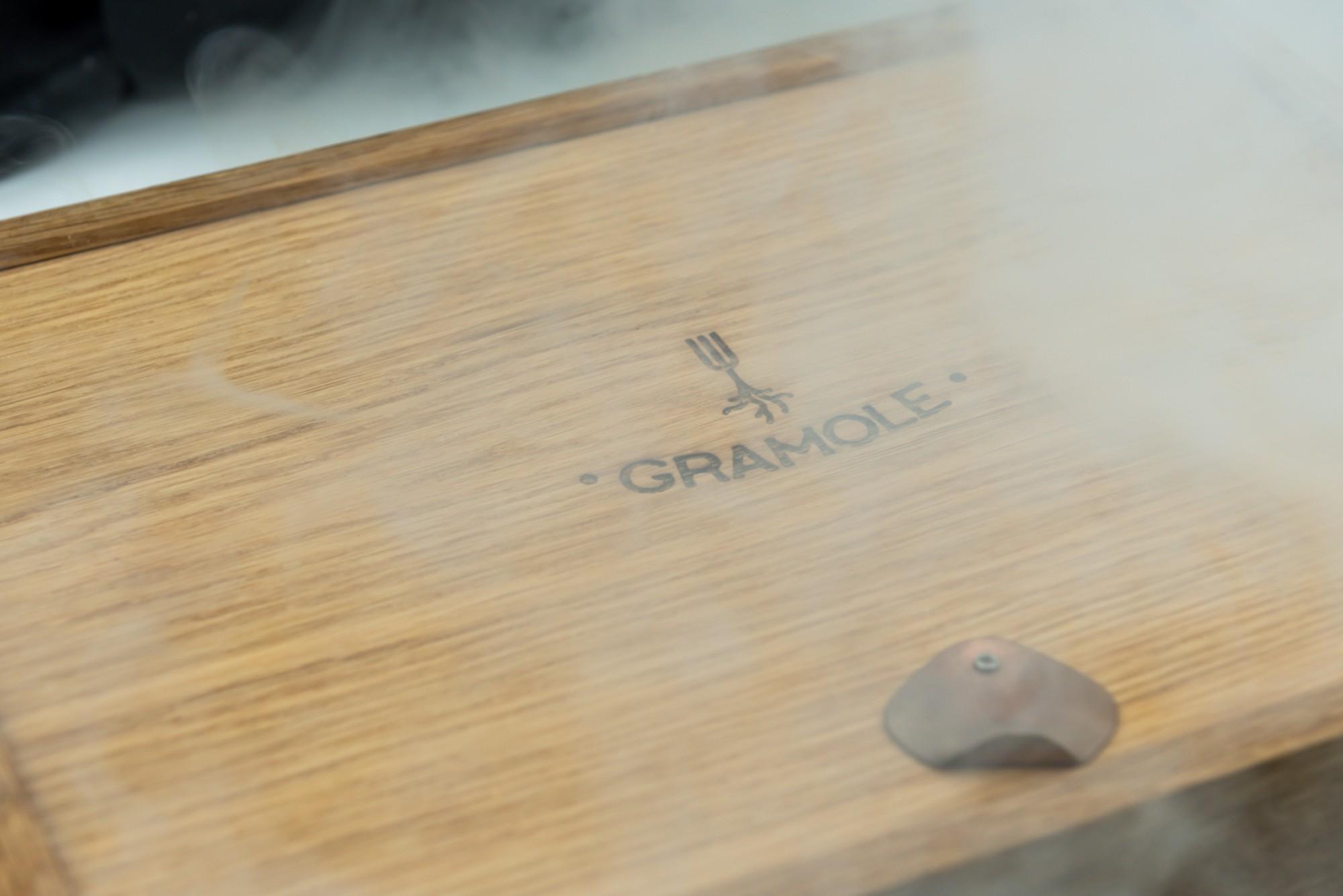 Planche en bois avec le logo Gramole enveloppée de fumée